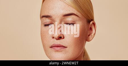 Gros plan en studio d'une jeune belle femme blonde avec des taches de rousseur. Cliché recadré d'une femelle à la peau lisse. Gros plan en studio d'un jeune Beautifu Banque D'Images