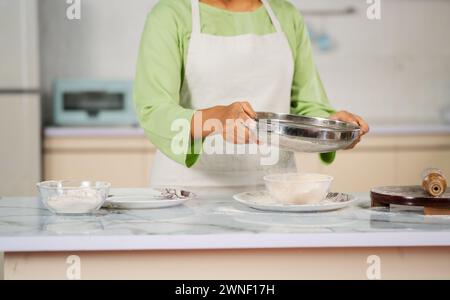 Gros plan d'une femme indienne préparant de la farine pour faire des chapati à la cuisine - concept de nourriture maison, une alimentation saine et la préparation des aliments Banque D'Images