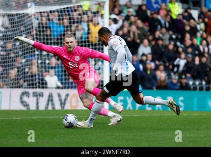 Nathaniel Mendez-Laing (à droite) du comté de Derby tente de prendre le ballon devant le gardien de Port Vale Connor Ripley (à gauche) sauve aux pieds du match de Sky Bet League One à Pride Park, Derby. Date de la photo : samedi 2 mars 2024. Banque D'Images