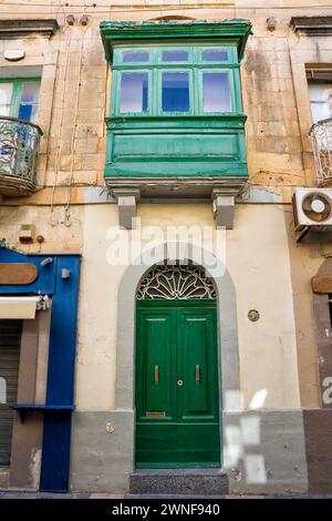 Façade d'une maison typique avec balcons fermés par des fenêtres et des portes typiques de Malte Banque D'Images