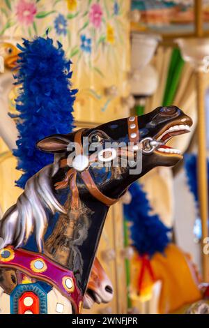 Gros plan d'une tête de cheval noir sur un carrousel de parc d'attractions à Lucques, en Italie Banque D'Images