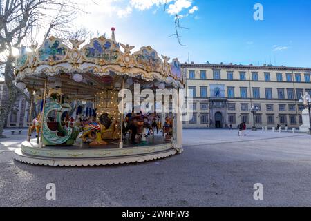 Carrousel coloré en face du Palazzo Ducale sur la Piazza Napoleone dans le centre historique de la ville médiévale de Lucques, en Italie Banque D'Images