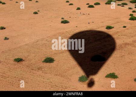 Une ombre de montgolfière au-dessus du désert d'Agafay sur le Maroc. Banque D'Images