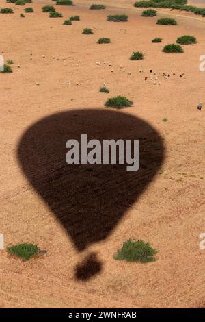 Une ombre de montgolfière au-dessus du désert d'Agafay sur le Maroc. Banque D'Images