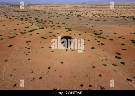 Une ombre de montgolfière au-dessus des déserts d'Agafay sur le Maroc. Banque D'Images