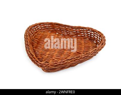 Panier isolé en osier en forme de coeur. Panier tissé vide en forme de coeur isolé sur fond blanc. Banque D'Images