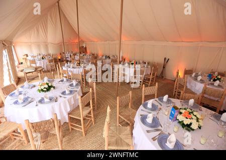 L'intérieur d'une tente kanvas prête à un banquet typique dans le désert d'Agafay près de Marrakech, Maroc Banque D'Images