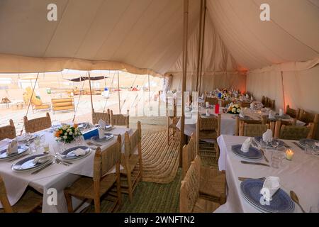 L'intérieur d'une tente kanvas prête à un banquet typique dans le désert d'Agafay près de Marrakech, Maroc Banque D'Images