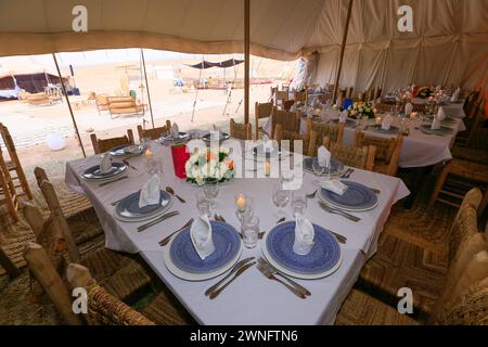 L'intérieur d'une tente kanvas prête à un banquet typique dans le désert d'Agafay près de Marrakech, Maroc Banque D'Images