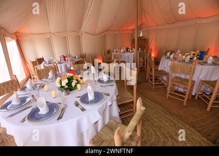 L'intérieur d'une tente kanvas prête à un banquet typique dans le désert d'Agafay près de Marrakech, Maroc Banque D'Images