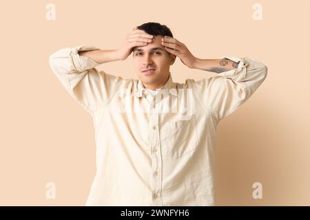 Jeune homme avec commotion cérébrale sur fond beige Banque D'Images