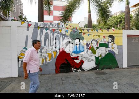 Caracas, Venezuela - mai 06, 2014 - homme marchant dans la rue dans la conception de devant sur le mur avec Hugo Chaves, Nicolas Maduro, Simon Bolivar, Ernesto Che Guevara, Banque D'Images