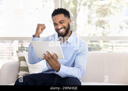 Joyeuse ravie la jeune femme africaine célébrant le triomphe Banque D'Images