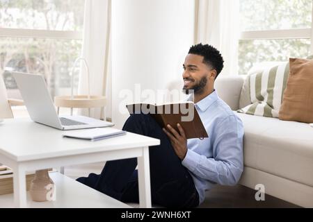 Homme étudiant afro-américain positif utilisant un ordinateur portable pour l'éducation en ligne Banque D'Images