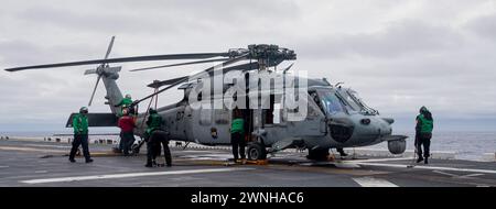 OCÉAN PACIFIQUE (23 février 2024) les marins affectés au HSC 25, Helicopter Sea combat Squadron (HSC), effectuent la maintenance d'un hélicoptère MH-60S à bord du porte-avions d'assaut amphibie déployé à l'avant USS America (LHA 6) lors d'opérations de routine dans l'océan Pacifique, le 23 février. America, navire chef de file de l'America Amphibious Ready Group, opère dans la zone d'opérations de la 7e flotte américaine. La 7e flotte américaine est la plus grande flotte numérotée déployée vers l’avant de l’US Navy. Elle interagit et opère régulièrement avec des alliés et des partenaires pour préserver une région indo-pacifique libre et ouverte. (Photo de l'US Navy Banque D'Images