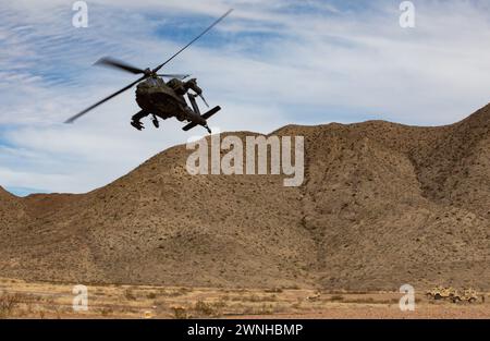 Les soldats de l'armée américaine de Delta Co, 1er bataillon, 114e régiment d'infanterie, 44e équipe de combat de la brigade d'infanterie, de la garde nationale de l'armée du New Jersey, effectuent un exercice de tir réel monté avec le soutien de l'hélicoptère Apache AH-64 du 1er 501 bataillon d'attaque et de reconnaissance, à Fort Bliss, Texas, le 25 février 2024. L'exercice faisait partie d'un exercice de tir réel combiné d'armes alors que le 44th IBCT se prépare pour le déploiement à l'appui de la Force opérationnelle interarmées combinée du Commandement central des États-Unis - opération Inherent Resolve. (Photo de la Garde nationale de l'armée américaine par le sergent d'état-major Bruce Daddis) Banque D'Images