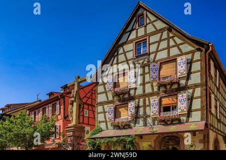 Des maisons traditionnelles à colombages ornées de fleurs fleuries dans un village populaire sur la route des vins d'Alsace dans le vignoble de Kaysersberg, en France Banque D'Images