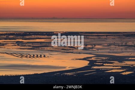 Lever de soleil sur la baie de Fangar et le delta de l'Èbre vu du parc éolien Baix Ebre (Tarragone, Catalogne, Espagne) ESP : Amanecer sobre la Bahía del Fangar Banque D'Images