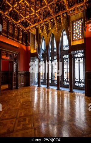 Salle de visite du palais Palau Güell, avec un plafond en bois spectaculaire et des fenêtres avec des arches paraboliques et des colonnes (Barcelone, Catalogne, Espagne) Banque D'Images