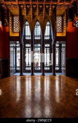 Salle de visite du palais Palau Güell, avec un plafond en bois spectaculaire et des fenêtres avec des arches paraboliques et des colonnes (Barcelone, Catalogne, Espagne) Banque D'Images