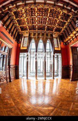 Salle de visite du palais Palau Güell, avec un plafond en bois spectaculaire et des fenêtres avec des arches paraboliques et des colonnes (Barcelone, Catalogne, Espagne) Banque D'Images