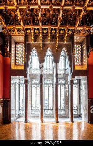 Salle de visite du palais Palau Güell, avec un plafond en bois spectaculaire et des fenêtres avec des arches paraboliques et des colonnes (Barcelone, Catalogne, Espagne) Banque D'Images