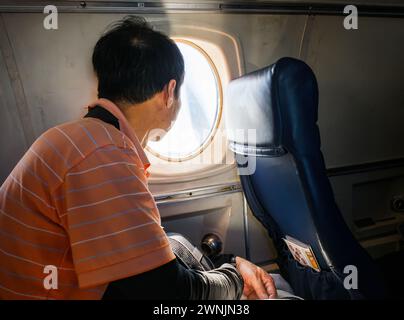 Passager regardant par une petite fenêtre d'avion. Avion décollant avec une hélice en mouvement. Alaska. Banque D'Images