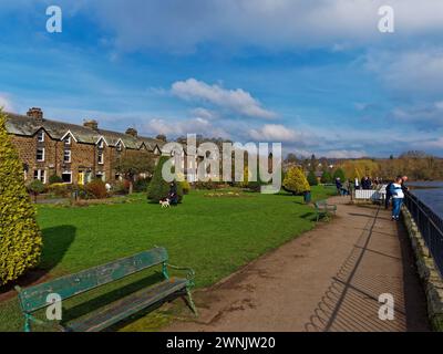 Les gens marchent le long du sentier à côté de la rivière Wharfe à Wharfe Meadows Park dans la ville d'Otley dans le Yorkshire par un dimanche après-midi ensoleillé. Banque D'Images