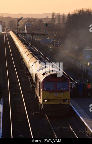 DB Cargo classe 60 locomotive diesel transportant un long train de marchandises de réservoirs d'huile à travers les signaux de sémaphore mécanique à Barnetby, Lincolnshire, Royaume-Uni Banque D'Images