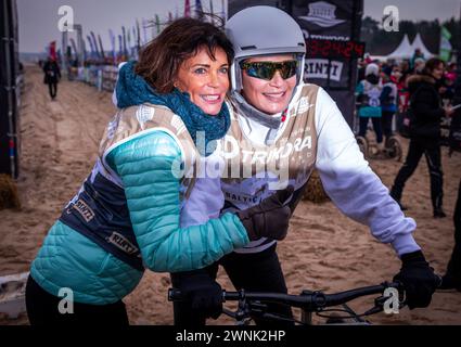 Heringsdorf, Allemagne. 02 mars 2024. Les actrices Gerit (à gauche) et Anja Kling (à droite) encouragent après avoir franchi la ligne d'arrivée à la course de chiens de traîneau « Baltic Lights » sur la plage de la mer Baltique sur l'île d'Usedom. Pour collecter des dons pour Welthungerhilfe, professionnels et célébrités s’affrontent en équipes de 500 huskies sur la plage. Environ 60 000 spectateurs sont attendus à l'événement caritatif de plusieurs jours le week-end. Crédit : Jens Büttner/dpa/Alamy Live News Banque D'Images