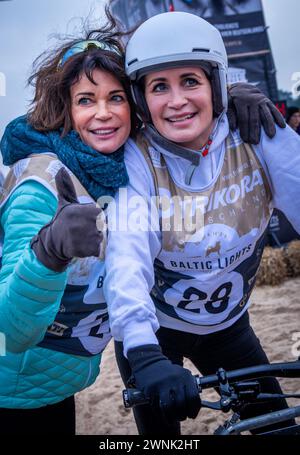 Heringsdorf, Allemagne. 02 mars 2024. Les actrices Gerit (à gauche) et Anja Kling (à droite) encouragent après avoir franchi la ligne d'arrivée à la course de chiens de traîneau « Baltic Lights » sur la plage de la mer Baltique sur l'île d'Usedom. Pour collecter des dons pour Welthungerhilfe, professionnels et célébrités s’affrontent en équipes de 500 huskies sur la plage. Environ 60 000 spectateurs sont attendus à l'événement caritatif de plusieurs jours le week-end. Crédit : Jens Büttner/dpa/Alamy Live News Banque D'Images