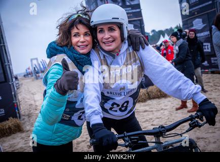 Heringsdorf, Allemagne. 02 mars 2024. Les actrices Gerit (à gauche) et Anja Kling (à droite) encouragent après avoir franchi la ligne d'arrivée à la course de chiens de traîneau « Baltic Lights » sur la plage de la mer Baltique sur l'île d'Usedom. Pour collecter des dons pour Welthungerhilfe, professionnels et célébrités s’affrontent en équipes de 500 huskies sur la plage. Environ 60 000 spectateurs sont attendus à l'événement caritatif de plusieurs jours le week-end. Crédit : Jens Büttner/dpa/Alamy Live News Banque D'Images