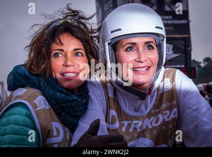 Heringsdorf, Allemagne. 02 mars 2024. Les actrices Gerit (à gauche) et Anja Kling (à droite) encouragent après avoir franchi la ligne d'arrivée à la course de chiens de traîneau « Baltic Lights » sur la plage de la mer Baltique sur l'île d'Usedom. Pour collecter des dons pour Welthungerhilfe, professionnels et célébrités s’affrontent en équipes de 500 huskies sur la plage. Environ 60 000 spectateurs sont attendus à l'événement caritatif de plusieurs jours le week-end. Crédit : Jens Büttner/dpa/Alamy Live News Banque D'Images