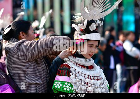 Kaili, province chinoise du Guizhou. 2 mars 2024. Une femme de l'ethnie Miao organise des ornements en argent pour sa fille pendant le festival Gannangxiang à Kaili, Qiandongnan Miao et dans la préfecture autonome de Dong, dans la province du Guizhou au sud-ouest de la Chine, le 2 mars 2024. À Kaili, les Miao de souche locale ont pour coutume d'enfiler leur tenue traditionnelle et de jouer Lusheng, un instrument de musique traditionnel, pour se réjouir du festival annuel de Gannangxiang, une célébration historique dans la province de Guizhou. Crédit : Yang Wenbin/Xinhua/Alamy Live News Banque D'Images