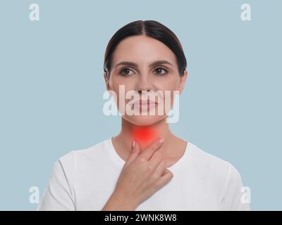 Système endocrinien. Femme faisant l'auto-examen thyroïdien sur fond bleu clair Banque D'Images
