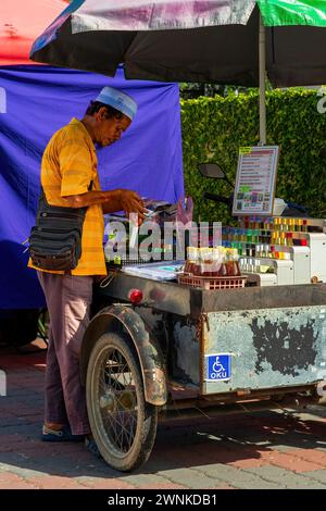 PERAK, MALAISIE - Oct 18, 2022 vendeur de motos avec handicap vend au marché du matin à Krai. Banque D'Images