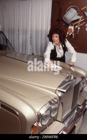 La première épouse de Pete Rose, Karolyn Englehardt, nettoie le capot de la Rolls Royce familiale peu de temps après que son mari soit devenu le premier homme de trois millions de dollars du baseball. Banque D'Images