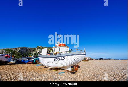 Petits bateaux de pêche traditionnels en bois traînés sur la plage de galets de Hastings, East Sussex, Angleterre Banque D'Images