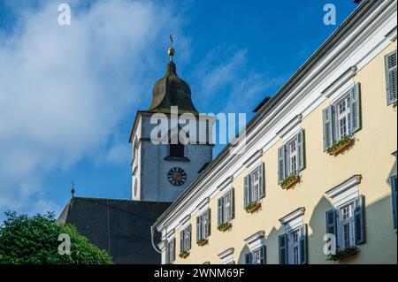 Tour historique de l'église avec horloge se dresse fièrement contre un ciel bleu clair avec des nuages, Sankt Wolfgang, Wolfgangsee, Salzkammergut, Autriche Banque D'Images