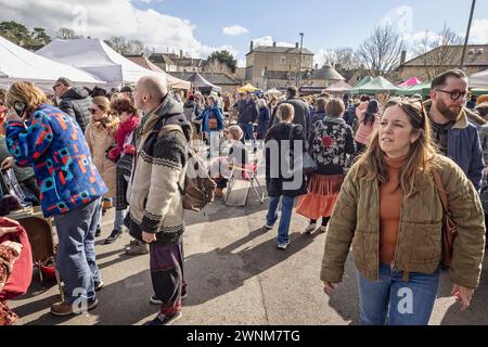 Des foules passant une dame assise au Frome Independent Sunday Market, Somerset, Royaume-Uni, le 3 mars 2024 Banque D'Images