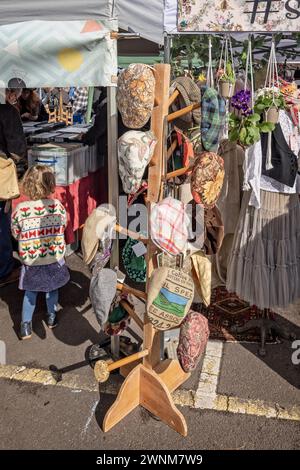 Assortiment de casquettes plates colorées en vente au Frome Independent Sunday Market le 3 mars 2024 Banque D'Images