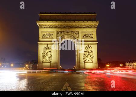 L'Arc de Triomphe dans la soirée pluvieuse. C'est l'un des monuments les plus célèbres de Paris. Il honore ceux qui se sont battus et sont morts pour la France. Banque D'Images