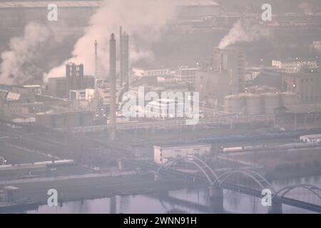 Lovosice, Tchéquie–16 février 2024 : les cheminées de fumée d'usine chimique polluent l'environnement, situation de smog industriel le matin brumeux. Intoxication par l'air. Banque D'Images