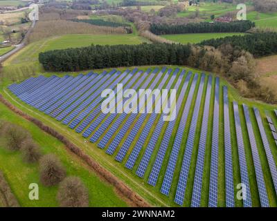 Prise de vue par drone capturant une vaste ferme de panneaux solaires au milieu de la verdure, mettant en valeur les énergies renouvelables Banque D'Images