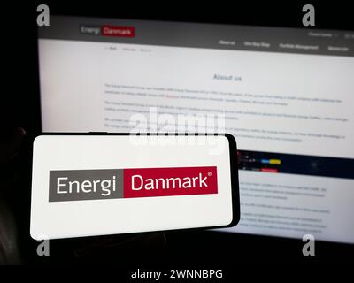 Personne tenant le téléphone portable avec le logo de la société danoise de négoce d'énergie Energi Danmark COMME en face de la page Web de l'entreprise. Concentrez-vous sur l'affichage du téléphone. Banque D'Images