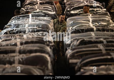 Azraq, Jordanie. 01 mars 2024. Un soldat de l'armée américaine sécurise des sangles sur des palettes d'aide humanitaire dans la soute d'un avion C-130J Super Hercules de l'US Air Force à la base aérienne Muwaffaq Salti, le 1er mars 2024 à Azraq, gouvernorat de Zarqa, Jordanie. L’aide alimentaire sera larguée par voie aérienne aux réfugiés palestiniens pris au piège de la guerre israélienne contre le Hamas. Crédit : TSGT. Christopher Hubenthal/US Airforce photo/Alamy Live News Banque D'Images
