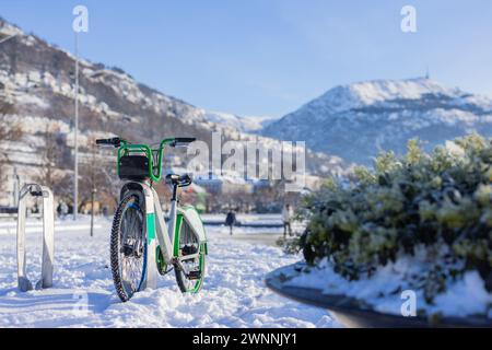 Location de vélos à Bergen, Norvège par une journée ensoleillée d'hiver. Béquille de location de vélos couverte et entourée de neige. Près du lac dans le centre de Bergen, simple bi Banque D'Images