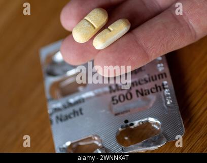 Berlin, Allemagne. 03 mars 2024. Un homme tient deux comprimés de magnésium dans sa main. Crédit : Monika Skolimowska/dpa/Alamy Live News Banque D'Images