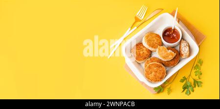 Plat de cuisson avec de savoureuses côtelettes de viande et sauce sur fond jaune avec espace pour le texte Banque D'Images