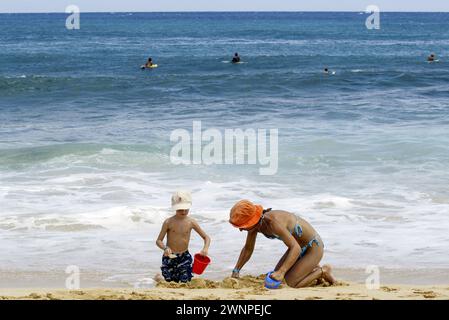 Bronzer, explorer les formations rocheuses, surfer et plonger depuis les falaises le long de Poipu Beach sur l'île de Kauai à Hawaï. Banque D'Images